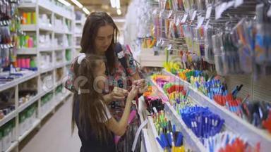 母女在文具店选择学习用品.. 家庭在超市选择文具写笔。